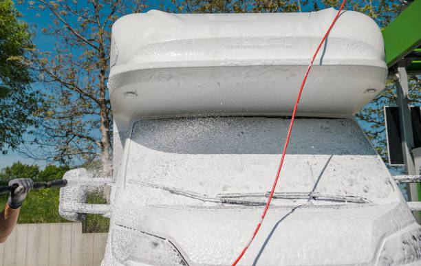 Large motorhome RV covered in soap during an exterior wash and detail